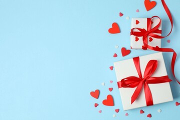 Gift boxes with red hearts on color background