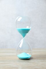 Modern hourglass on wooden table. Hourglass time concept for business deadline, urgency and outcome of time