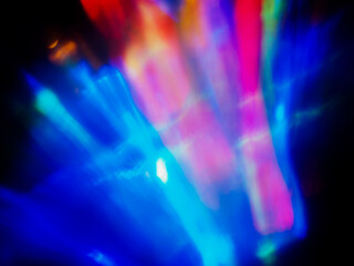 A colorful, blurry background with a rainbow of colors. The colors are bright and vibrant, creating a sense of energy and excitement. Abstract design wall paper. Cinematic light effect.