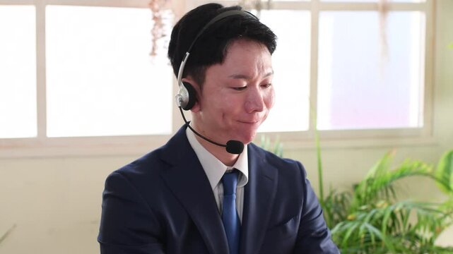 インカム付けて話をするスーツ姿の若い男性