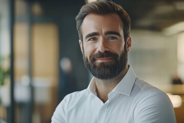 Naklejka premium male investor beard looking at camera and smiling in modern office