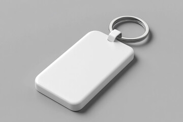 A blank white acrylic keychain with no text or design sitting on an isolated gray background.