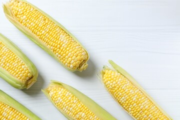 Fresh corn on cobs on light background, top view