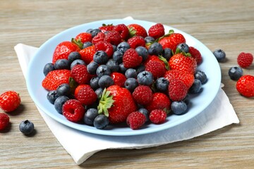 Different fresh ripe berries in bowl on the table
