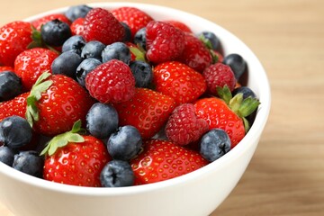 Different fresh ripe berries in bowl on the table