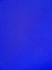 Blue breathable porous poriferous material for air ventilation with holes. Sportswear material nylon texture.