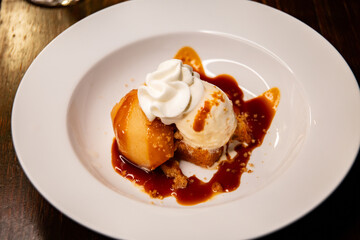 Ice Cream Dessert with pear on a white plate on table