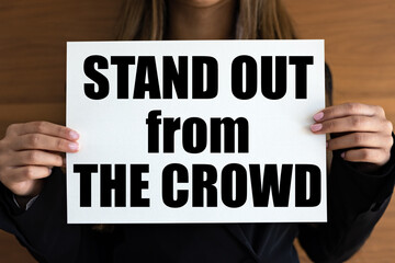 Stand out from the crowd. Woman with white page, black letters. Various, different, individual, unique.