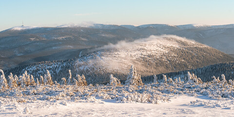 Hruby Jesenik, View of snow-capped mountain range from hiking trail during winter hike in the mountains, winter landscape in the mountains on a sunny day.