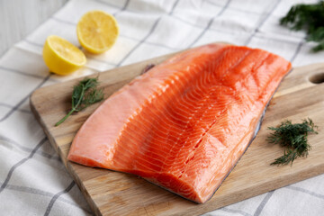 Organic Raw Salmon Fillet on a wooden board, side view.