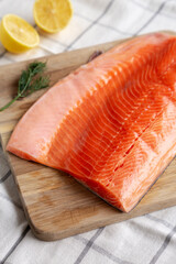 Organic Raw Salmon Fillet on a wooden board, side view.