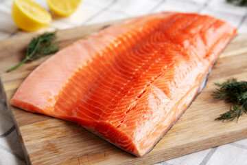 Organic Raw Salmon Fillet on a wooden board, side view.