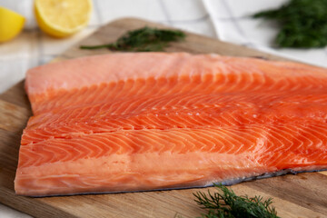 Organic Raw Salmon Fillet on a wooden board, side view.