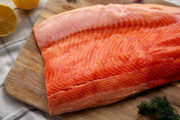 Organic Raw Salmon Fillet on a wooden board, top view. Flat lay, overhead, from above.
