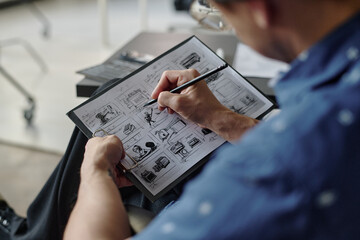 High angle shot of unrecognizable man holding graphite pencil and sketching on paper