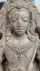 Close-up of a detailed stone statue of a Hindu goddess, highlighting intricate facial features and ornate jewelry