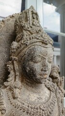 Close-up of a detailed stone statue of a serene Hindu deity, showcasing intricate carvings and textures