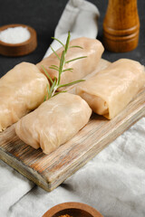 Close-up view of cabbage spring rolls stuffed with meat on a wooden board