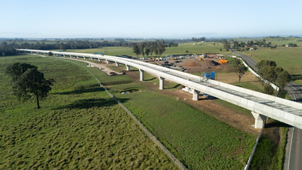Fototapeta premium Aerial drone view of the construction of the viaduct for the new metro line looking in the east direction in Western Sydney, NSW Australia on a sunny day in December 2024 