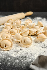 Handmade dumplings with chicken on a floured countertop ready for cooking