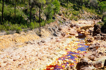 Rio Tinto river and iron mines. Red tinted river by copper, iron on the ground. Water used in life...