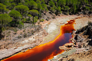 Rio Tinto river and iron mines. Red tinted river by copper, iron on the ground. Water used in life...