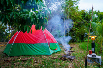 Mountain forest camping tent under a summer sky