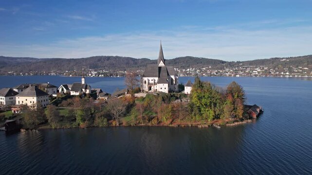 Flight over of Maria Worth church on Lake Worthersee, in Carinthia, Austria.