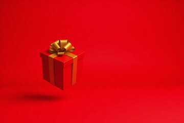 Suspended red gift box with golden ribbon