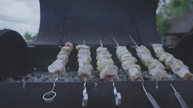 Marinated juicy pork strung on skewers for barbeque grills on mangal. Marinated meat strung on skewers grills above hot coals for garden party
