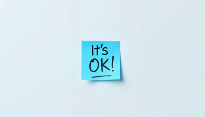 Minimalistic blue sticky note with “It’s OK” on blank whiteboard, simple composition for Blue Monday