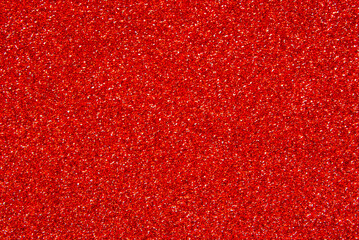 Red color glitter paper texture close up as background