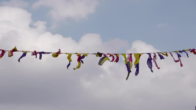 Signal naval flags of different colors fluttering in the wind.
