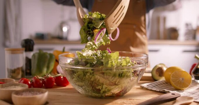 Healthy Home Cooking: Tossing a Nutritious Mediterranean Salad Packed with Fresh Vegetables in a Bright, Sunlit Space