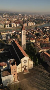 drone aerial video of historical unesco heritage Italian Verona San Zeno church with chapel on piazza in sunny day 