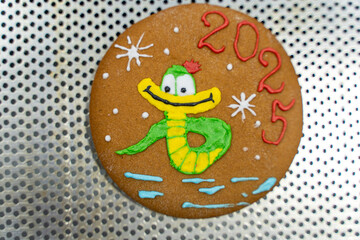 Gingerbread cookies with the image of the Snake symbol of the new year 2025. Christmas treat for children. Master class.