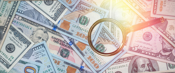 magnifier glass with US USD paper dollar bills