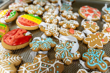 New Year's or Christmas cookies in the form of snowflakes and Christmas balls with ribbons on the production table. Making gingerbread toys for the Christmas tree in the bakery.