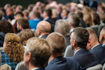Crowded gathering of professionals attending a conference or meeting in a corporate setting