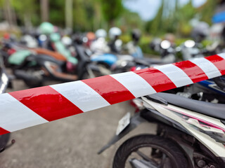 red and white barricades or barrier tape with parked motorbikes in the background. concept of...