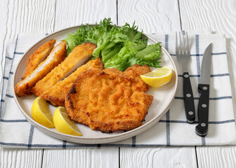Pork Milanese with lettuce and lemon on a plate