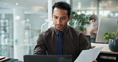 Business, man and documents with laptop in office for data entry in CRM system and online sales...
