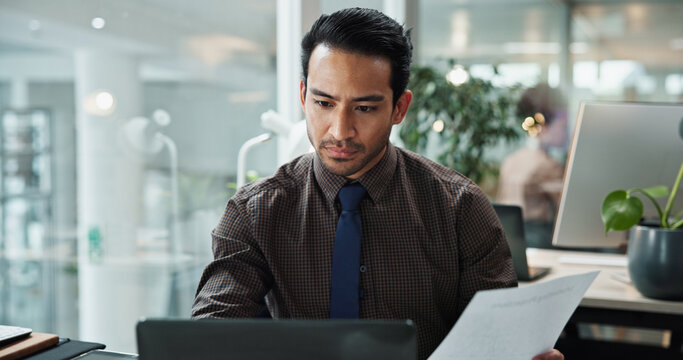 Business, man and documents with laptop in office for data entry in CRM system and online sales report. Account representative, employee and serious with client information update or portfolio review