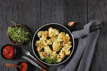 fried cauliflower florets on a skillet, top view