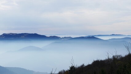 Serene Landscape of Mist-Covered Mountain Ranges 