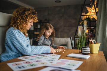 Fototapeta premium little girl and speech therapist practice together at home