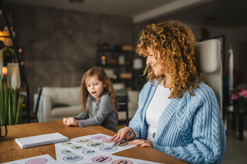 little girl and speech therapist practice together at home