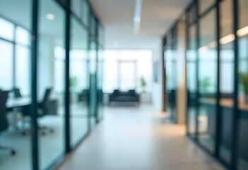 Blurred interior of a modern office with glass walls and doors , and some furniture visible in the background.