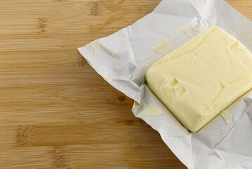 A stick of butter placed on a cutting board, increase in butter prices, food prices