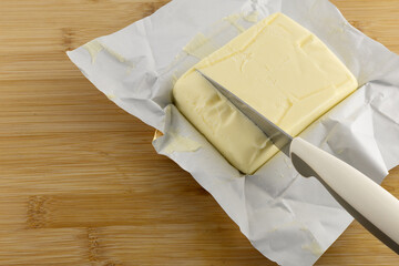 A stick of butter placed on a cutting board, increase in butter prices, food prices